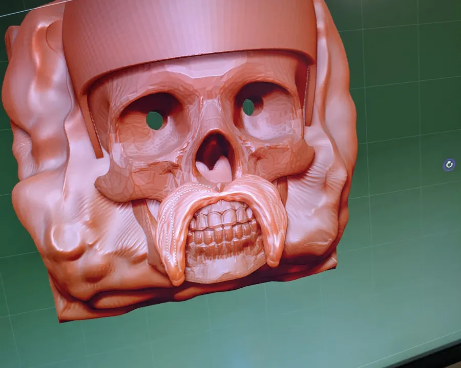 A skull keycap design being sculpted in 3D software on a monitor