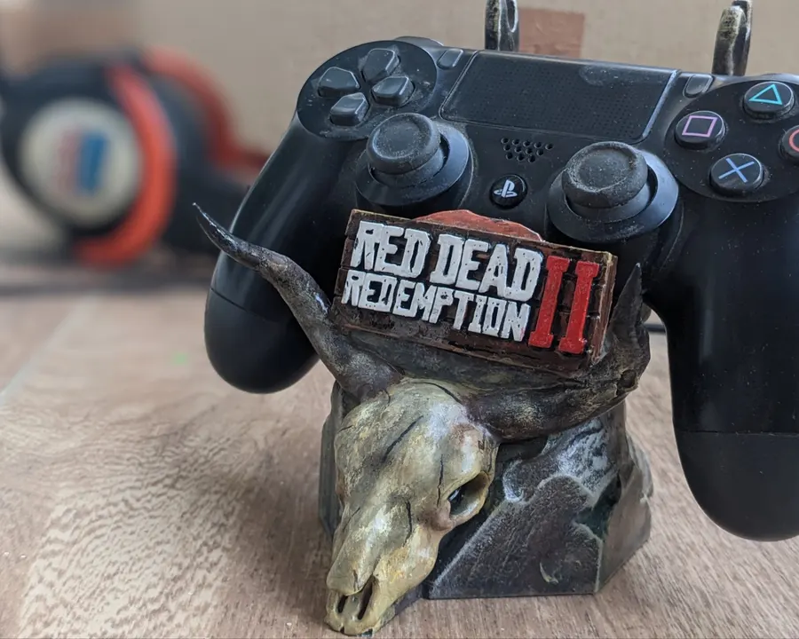 A hand-painted controller stand shaped like a horned skull, holding a game controller